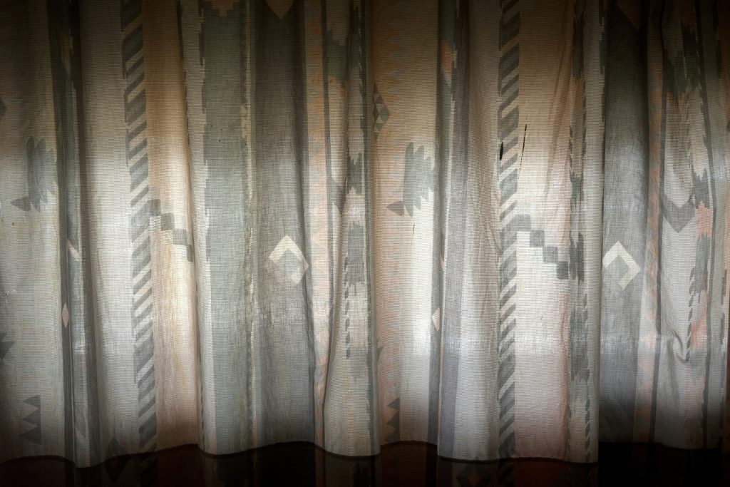 Una habitación con una cortina que tiene un patrón.