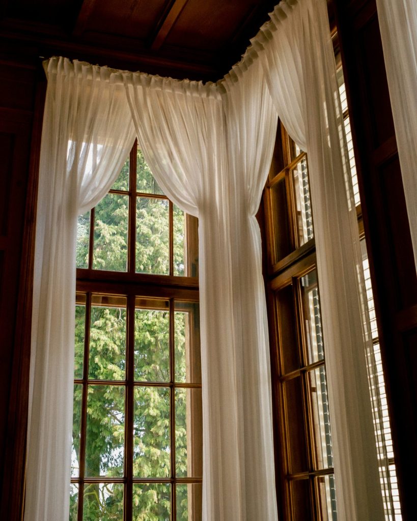 White curtains frame a bright window.